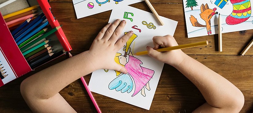 Barn färglägger en teckning med pennor.